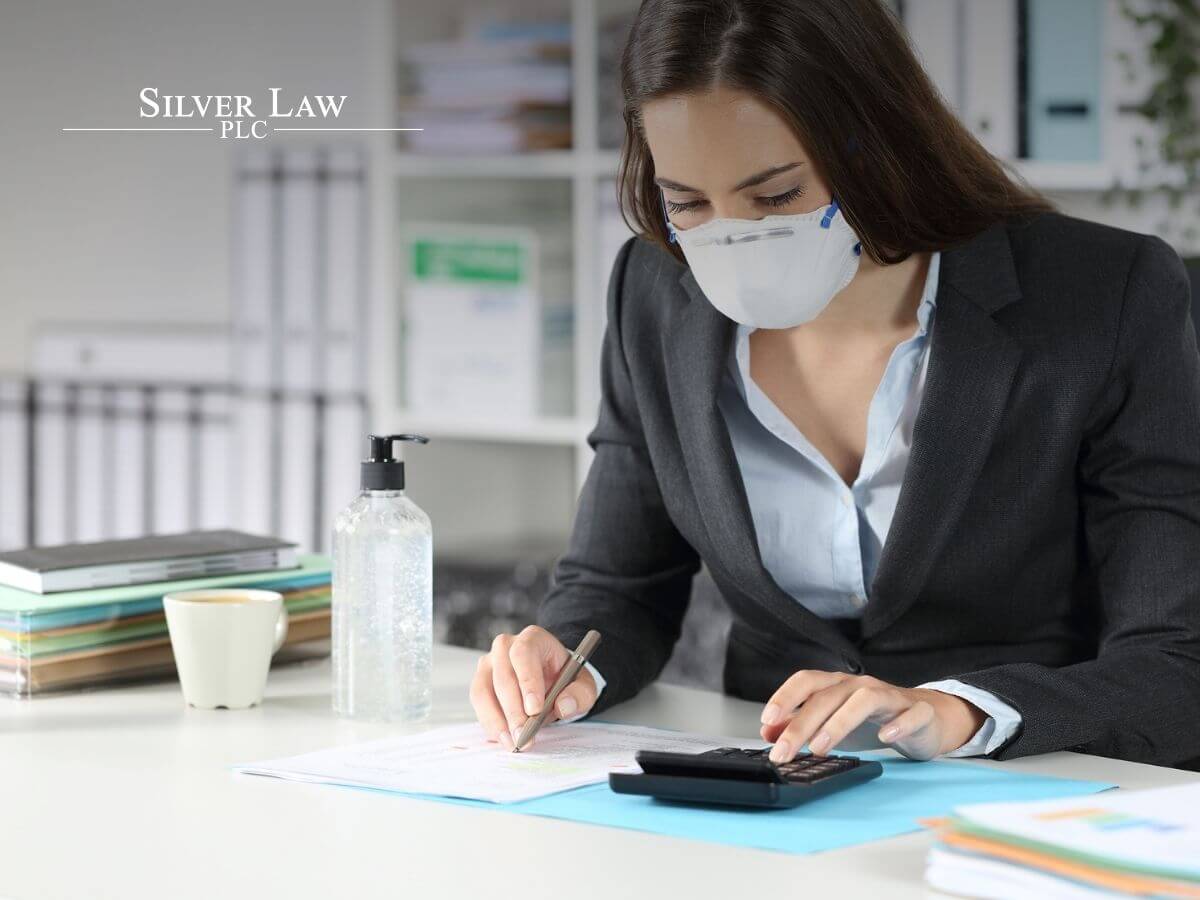 business woman with protective mask calculating annual tax
