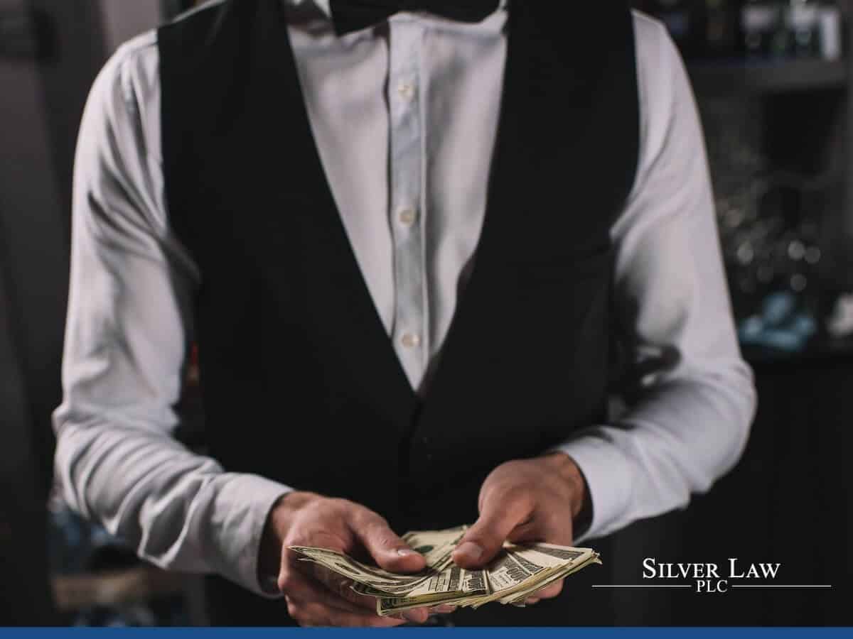 Bartender counting his tips at bar counter