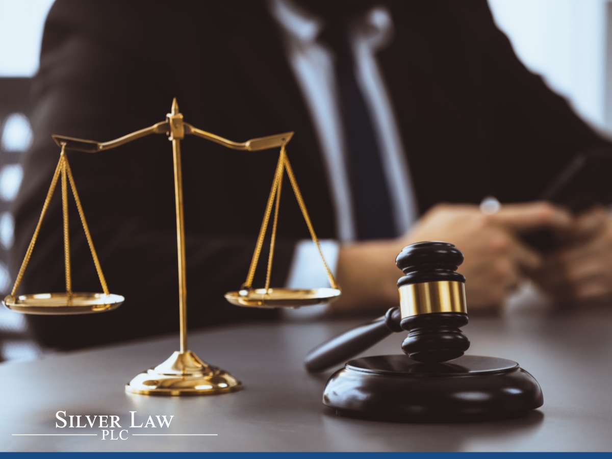 Scales of justice and a gavel on a desk, indicating legal aspects of the Corporate Transparency Act