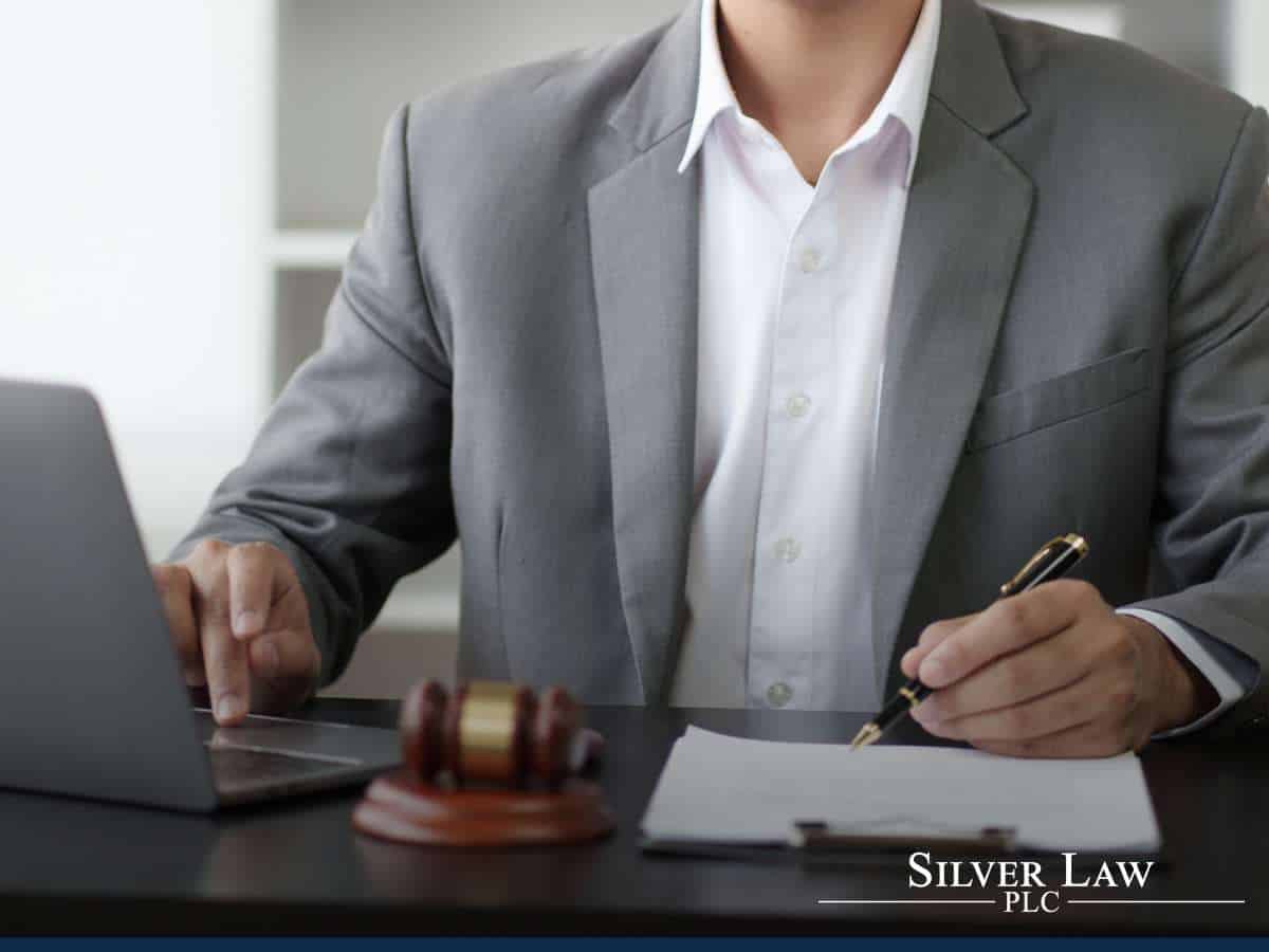 Lawyer reviewing documents with a focus on Social Security taxes in his office